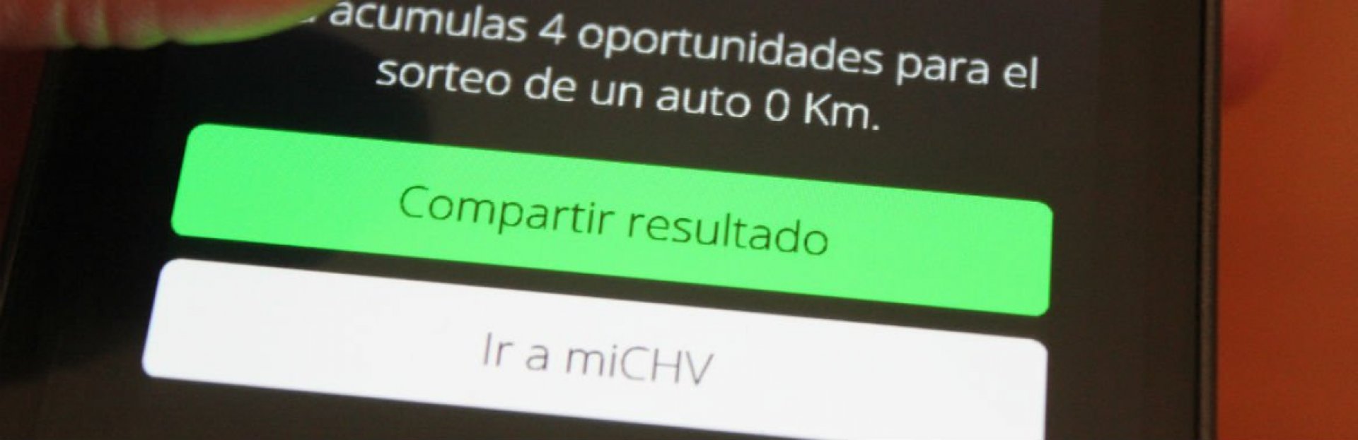 Mano sosteniendo un smartphone con la aplicación Pincha en Primer Plano