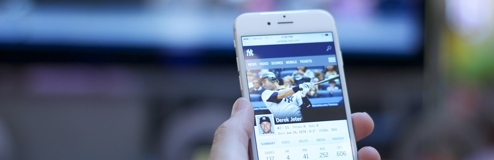 Smartphone con aplicación de beisbol frente a la TV