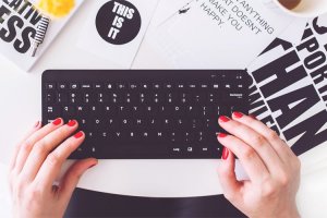 Mujer escribiendo sobre un teclado de computadora