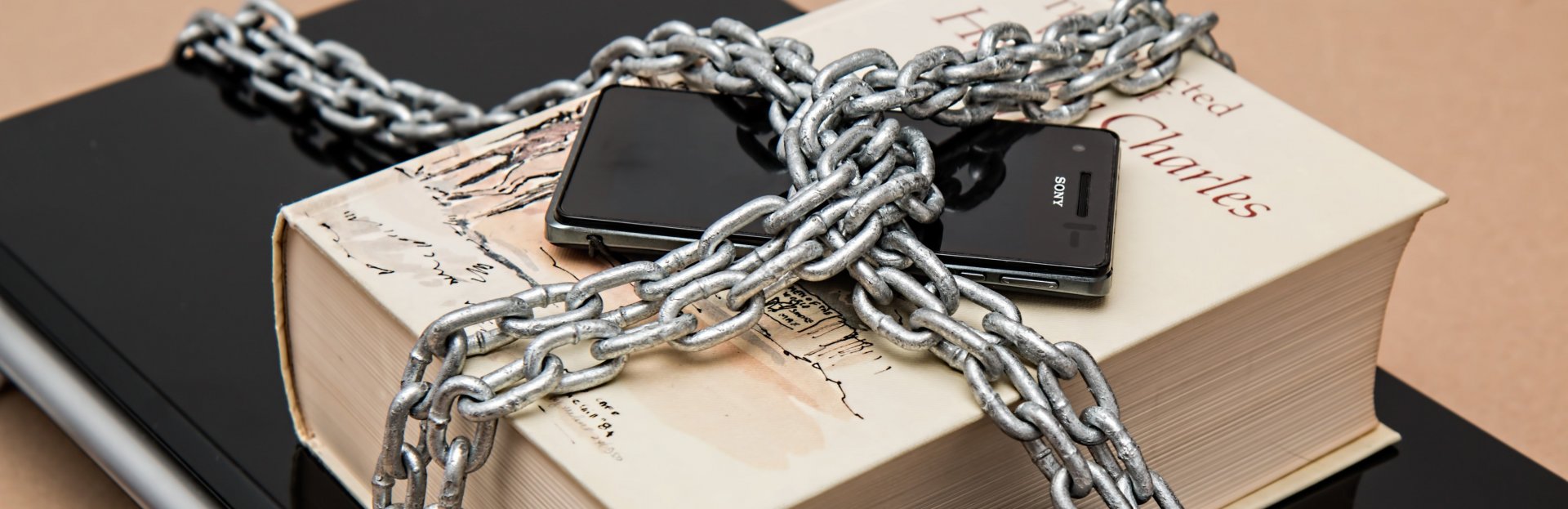 Tablet, libro y celular encadenados
