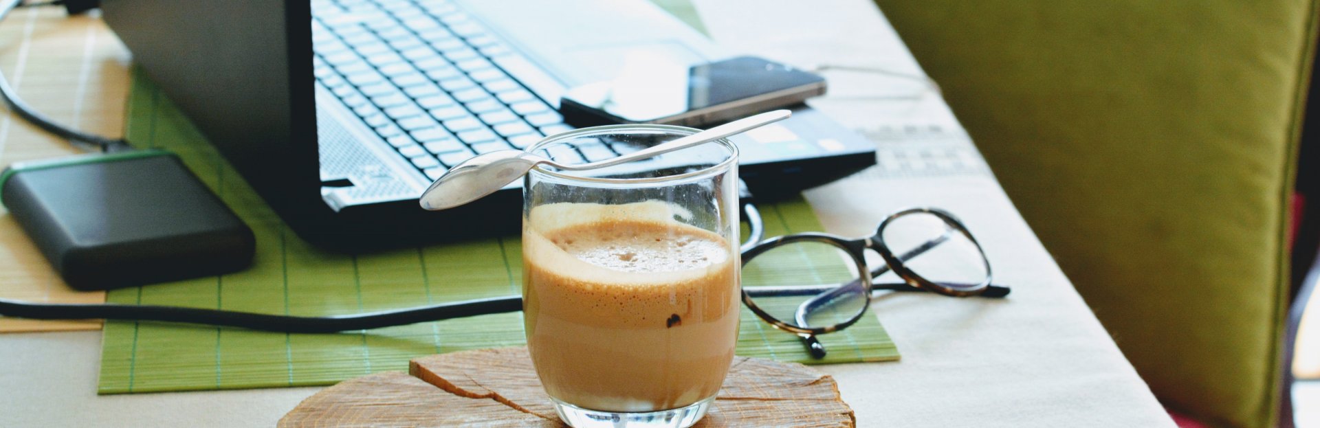 Laptop, gafas y un café sobre un escritorio
