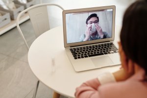 Mujer en videoconferencia con hombre con mascarilla