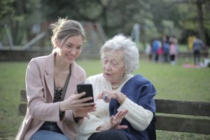 Abuela e hija adulta mirando un smartphone