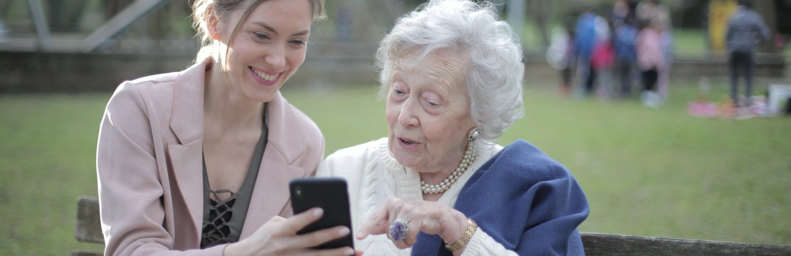 Abuela e hija adulta mirando un smartphone